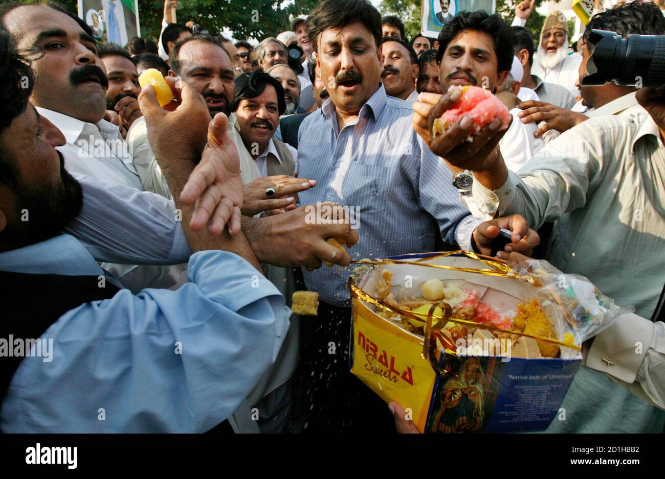 supporters-of-pakistans-exiled-former-prime-minister-nawaz-sharif-eat-sweets-as-they-celebrate-outside-the-supreme-court-building-in-islamabad-august-23-2007-sharif-said-on-thursday-he-intended-to-return-home-as-soon-as-possible-and-contest-elections-to-try-to-oust-president-pervez-musharraf-from-office-reutersmian-khursheed-pakistan-2D1HBB2.jpg