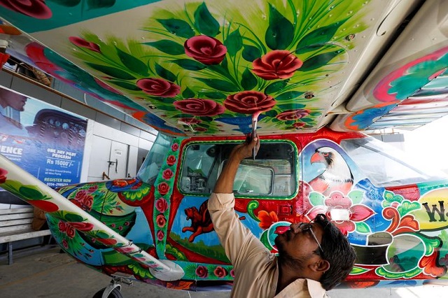 a man paints pakistani truck art on a two seater cessna aircraft at general aviation area at jinnah international airport in karachi pakistan december 30 2020 photo reuters