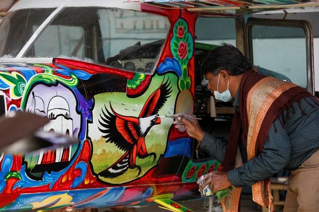 Painter Haider Ali, 40, paints Pakistani truck art on a two-seater Cessna aircraft at general aviation area at Jinnah International Airport in Karachi, Pakistan, December 30, 2020. PHOTO: REUTERS