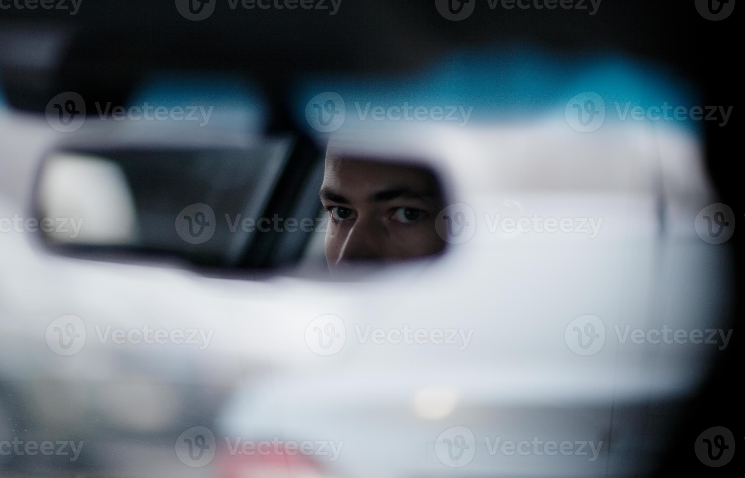 man-looking-in-the-rear-view-mirror-while-driving-photo.jpg